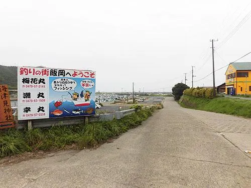 「釣りの街 飯岡へようこそ」の看板横の坂を下りると港
