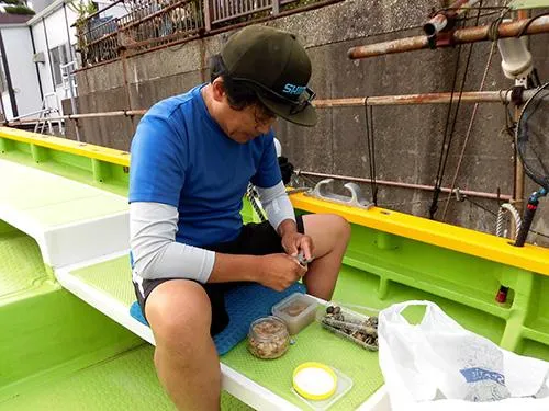 持参したアサリの殻を剥く釣り人