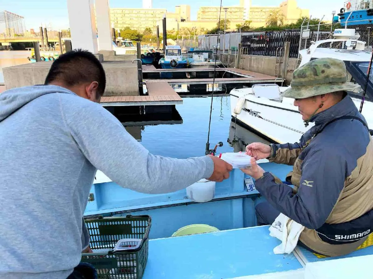 釣座で乗船札と引き換えに餌の配布　©釣りビジョン