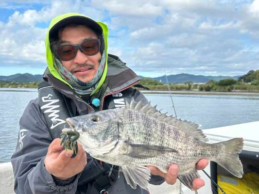 ほっかむりのようないでたちでチヌを釣り上げるセンドウタカシ。&copy;釣りビジョン