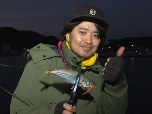 強い向かい風の夕マヅメ。古賀は尺ヘッドR2.5g、ワームはシャッド系で開始。アジの回遊があるまで、ただ黙々と待ちの釣りが続く。最初にヒットしたのは高橋！昨日と同じ時刻に時合い到来！丸々太ったアジをゲット！続いたのは古賀。ショートバイトが2度ほどあり、「サイズ感とスピードかな？」と尺ヘッドを1.5gに落としワームの太さを2.5インチの細いものに変えると読みが見事に的中。連続ヒットに持ち込む。「久しぶりに持って帰ってアジ刺しにしようかな〜」とニンマリ。&copy;釣りビジョン