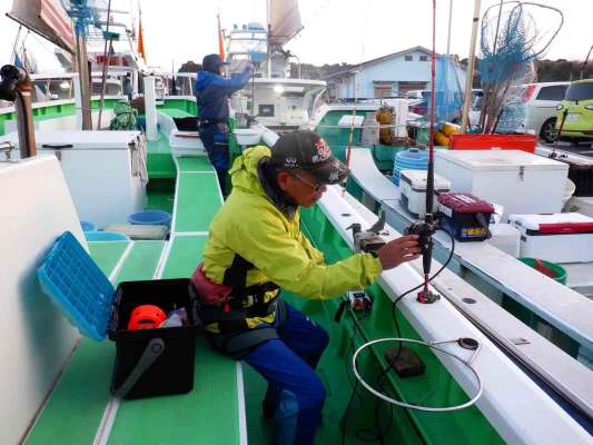 スタッフに手伝ってもらい船に乗り込んだら早速釣り支度開始。 &copy;釣りビジョン