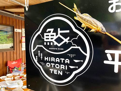 焼きたてのアユとオトリ店の看板と記念撮影