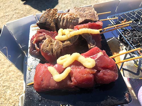 高知県柏島ロケでは、釣れた本ガツオをその場で串焼きにして食べた。ニンニクを豪快に使用するのがメタルバスター流