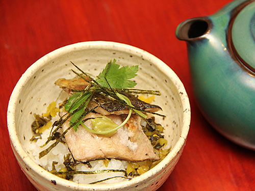 冷えたゴハンの上に、焼き上げたマスの切り身、薬味(シソの実、高菜)と練りワサビ、それに細く切った海苔を乗せる。最後に熱い玄米茶を注いで完成!