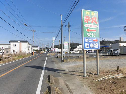 『幸丸』看板。道路を挟んで反対側が船宿