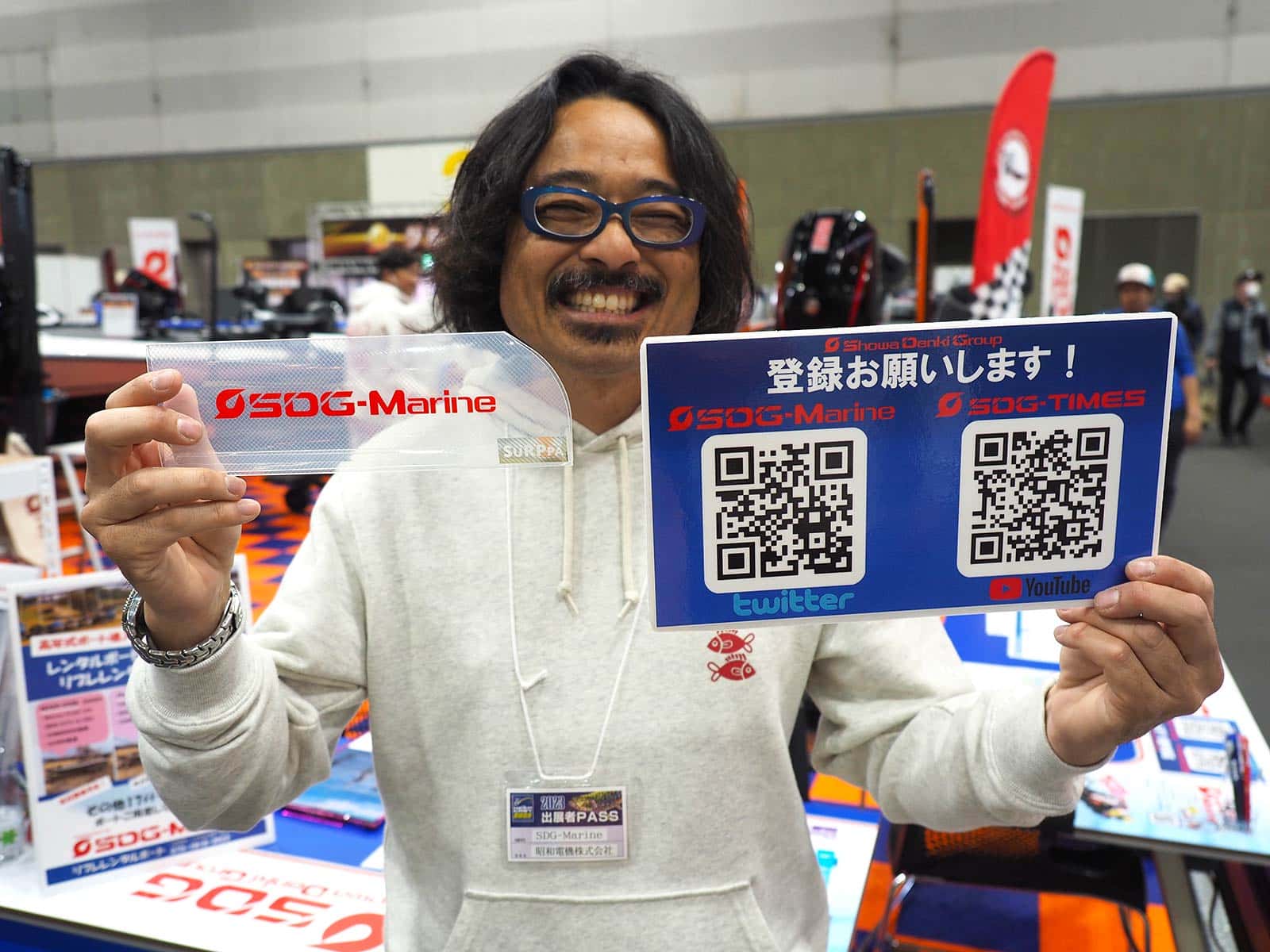 写真は業界のフィクサーとして知られるマイケルさん。SDGマリンのYOUTUBEにチャンネル登録した人には、ビッグベイトの収納に便利な「スルッパ」（SDGマリンロゴ入り）を配っていた（数量限定）