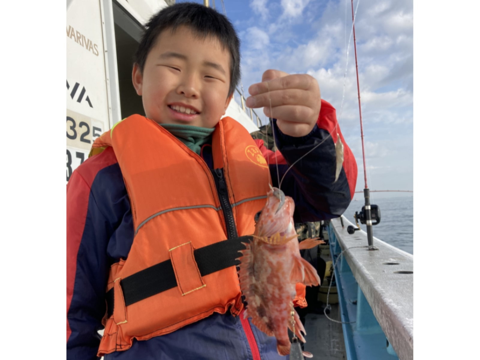 　　　　　　カサゴを釣ってニンマリ。船の上ではライフジャケットの着用は必須