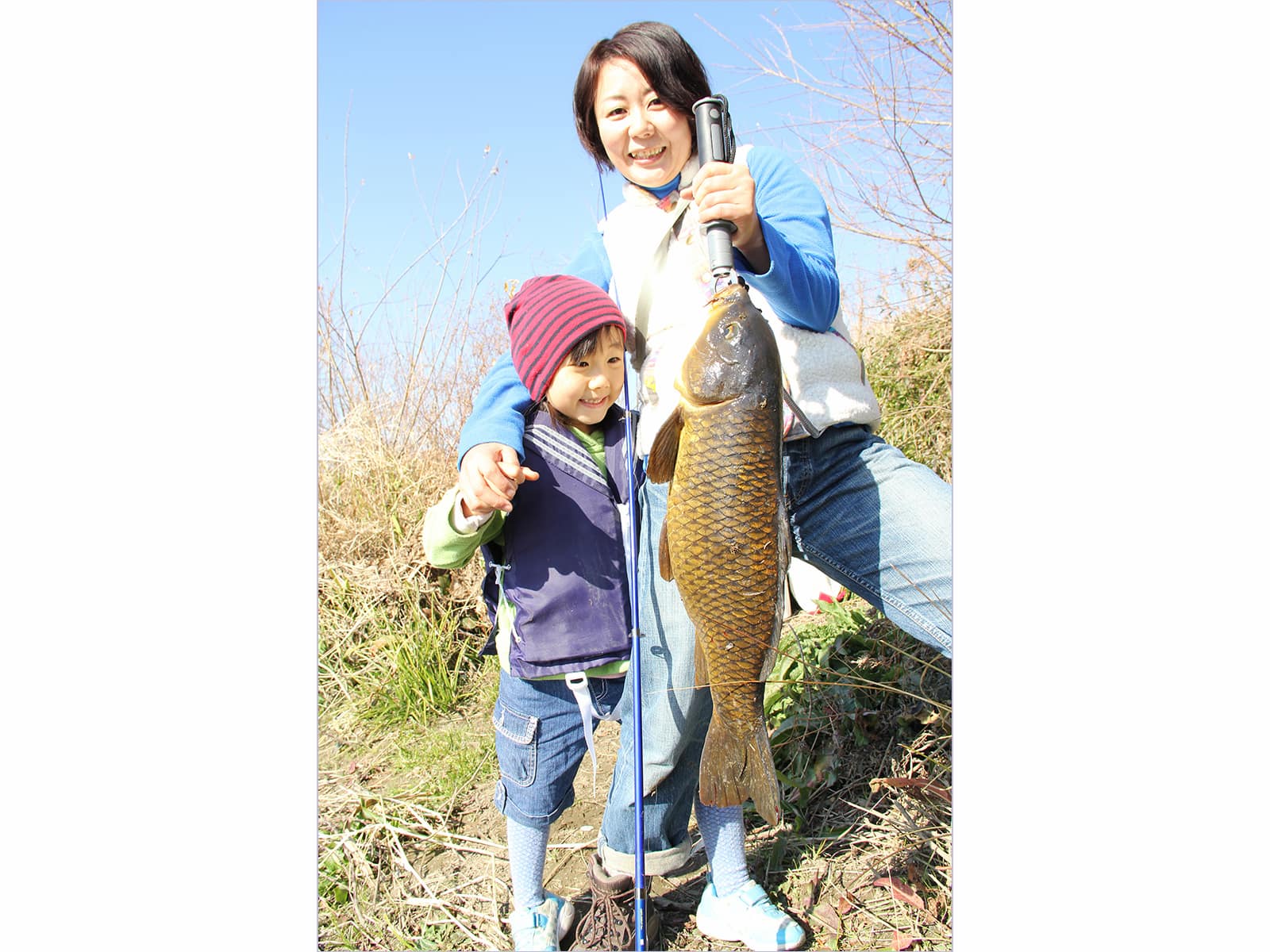 釣ったのは筆者。コイを持つのは奥さん。子どもの前で面目を保った。娘は60cmクラスのコイを目の当たりにして目を丸くする